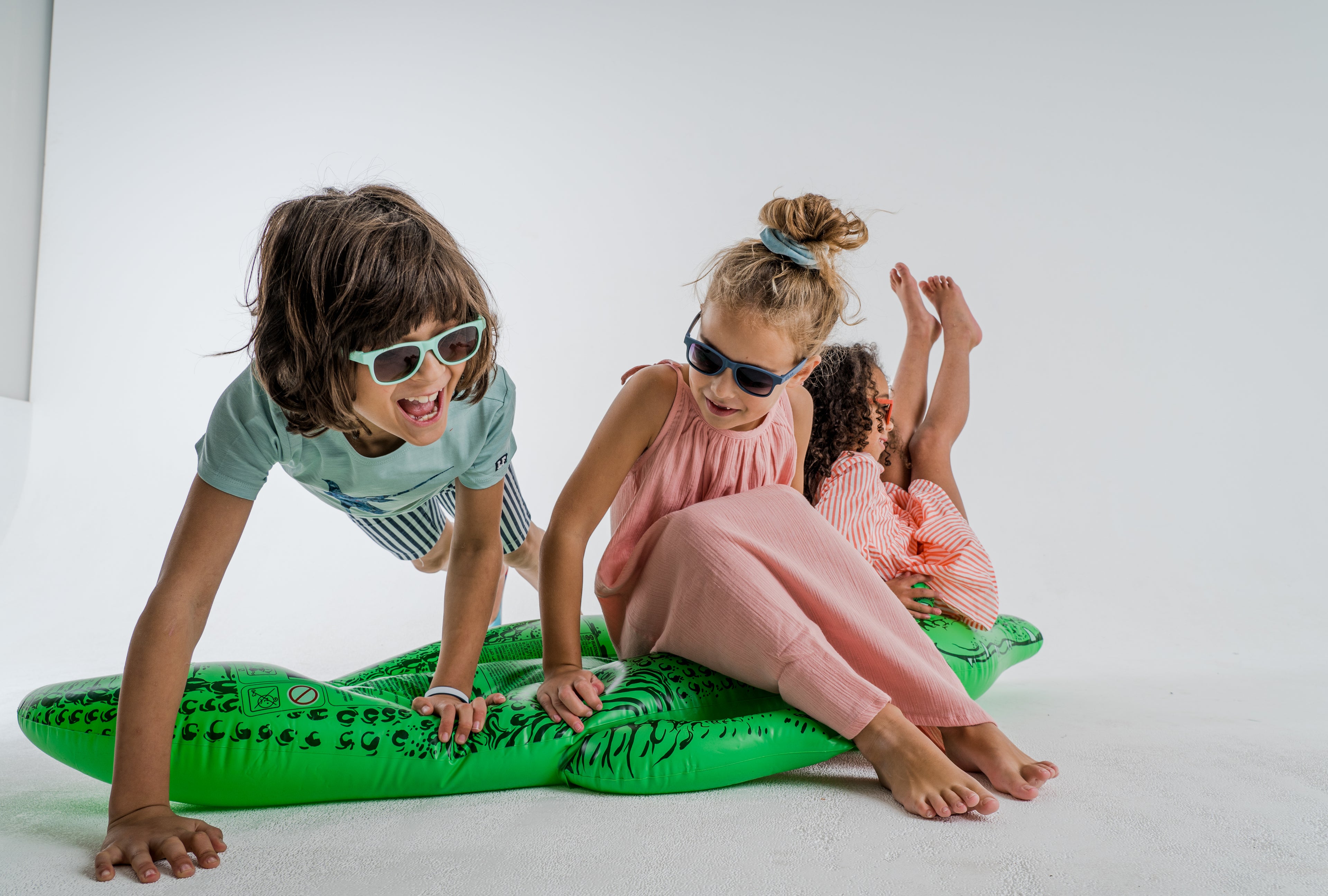 Kids met FatOncles SAM Mint kinderzonnebril op opblaas krokodil