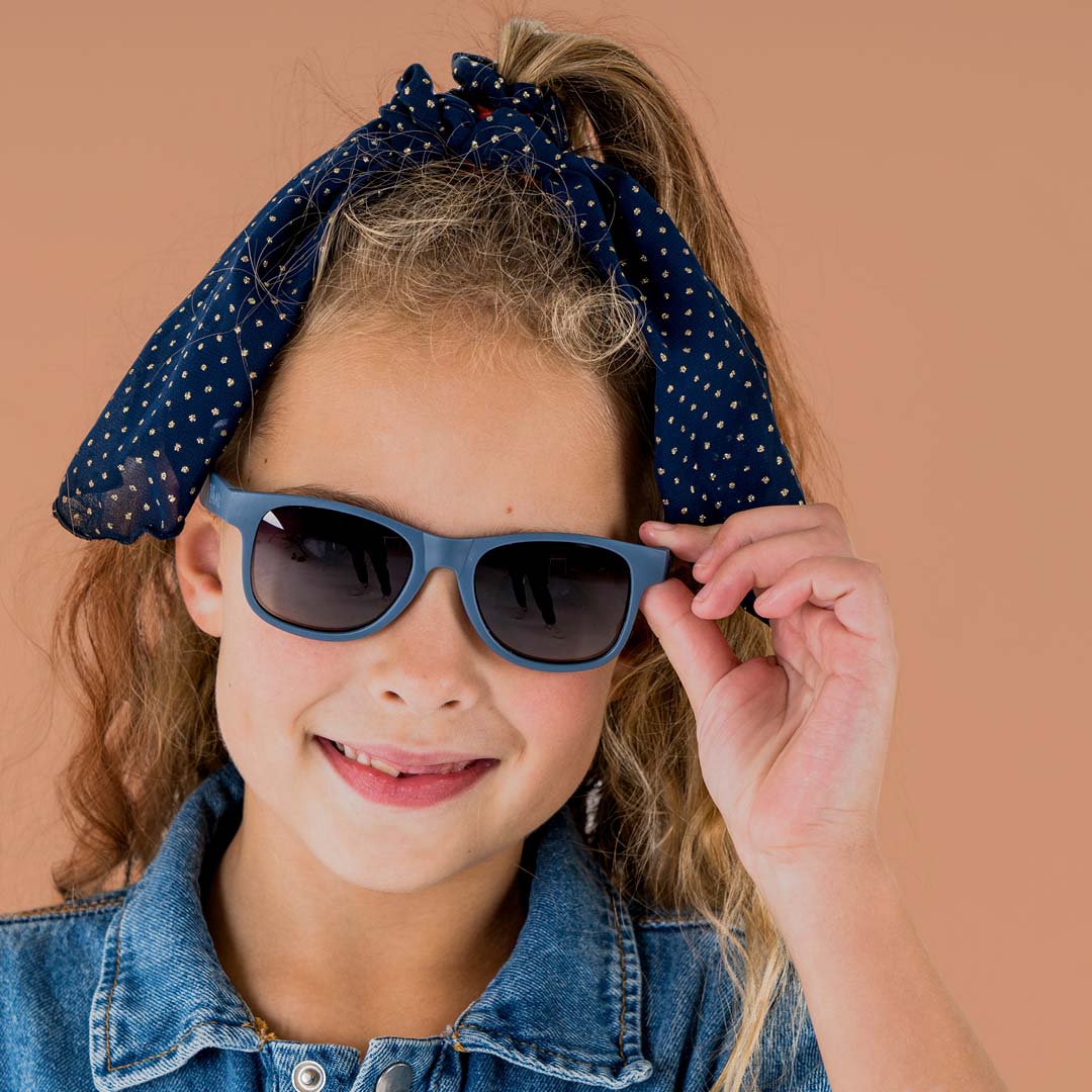 Kind met een donkerblauwe zonnebril op